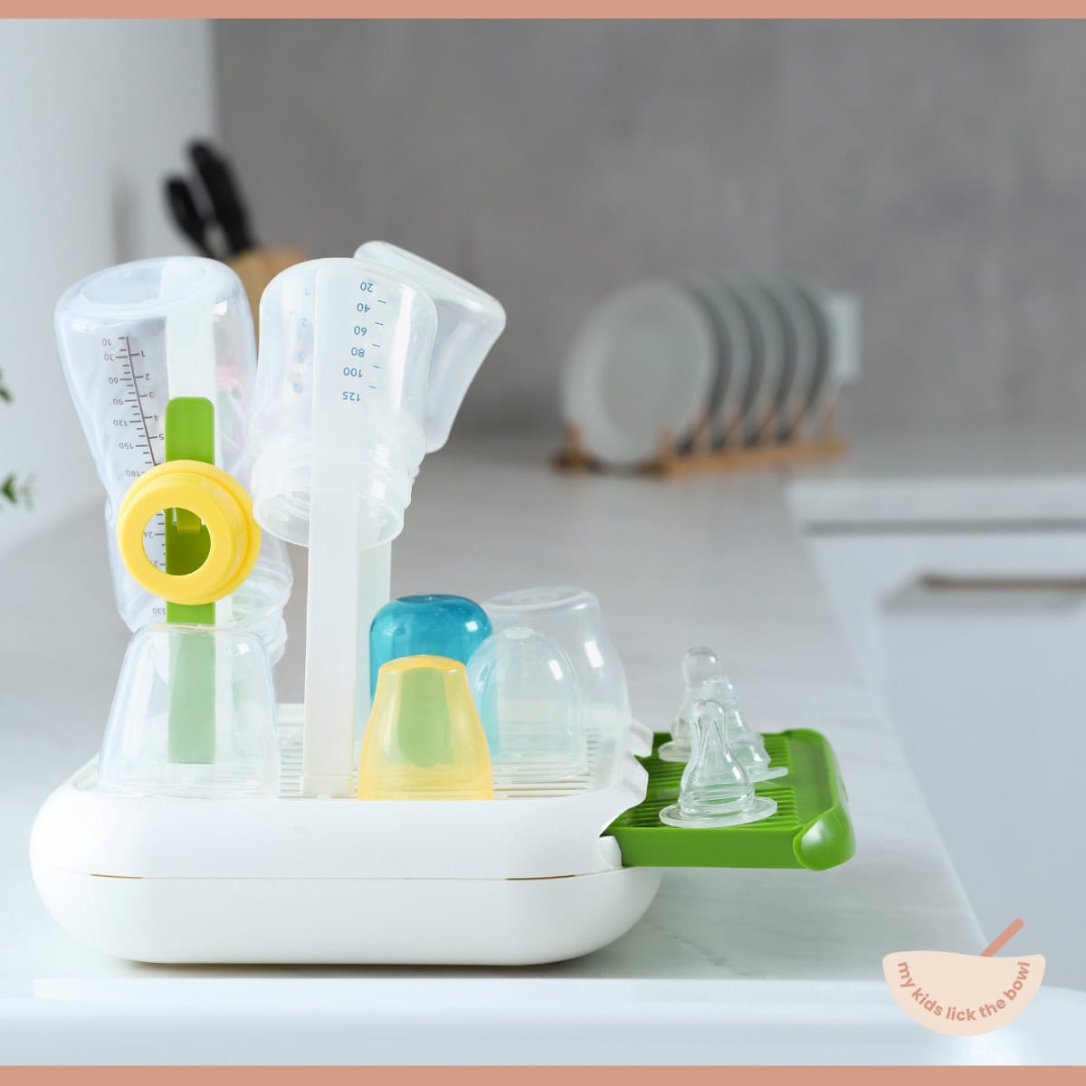 baby bottles on a drying rack on a kitchen counter.