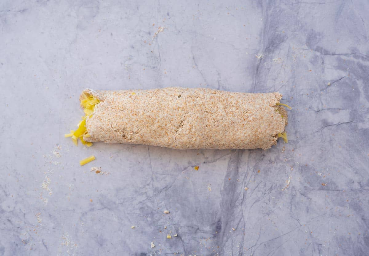 Pizza dough and fillings rolled into a log. 