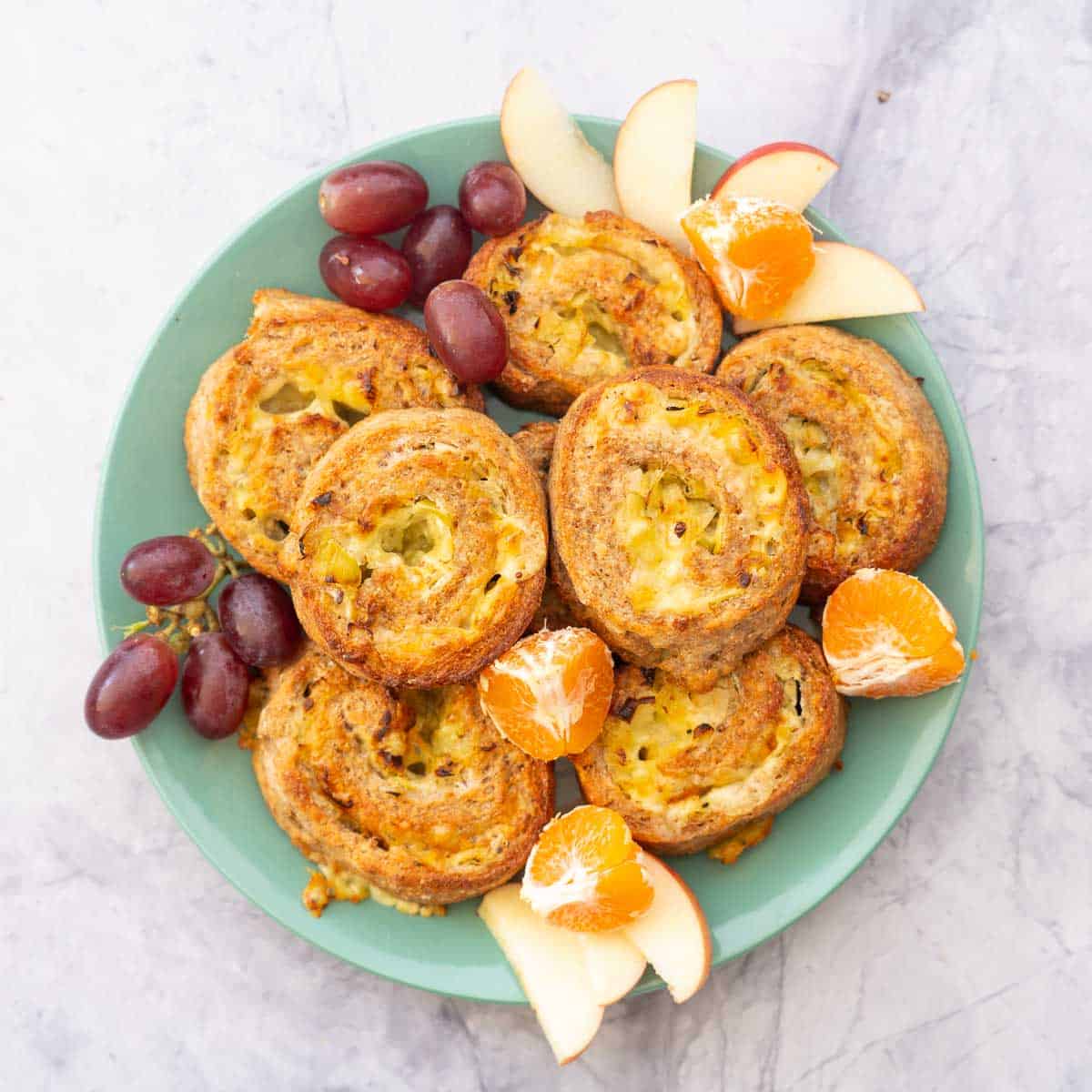 Scrolls on a green plate with fresh fruit