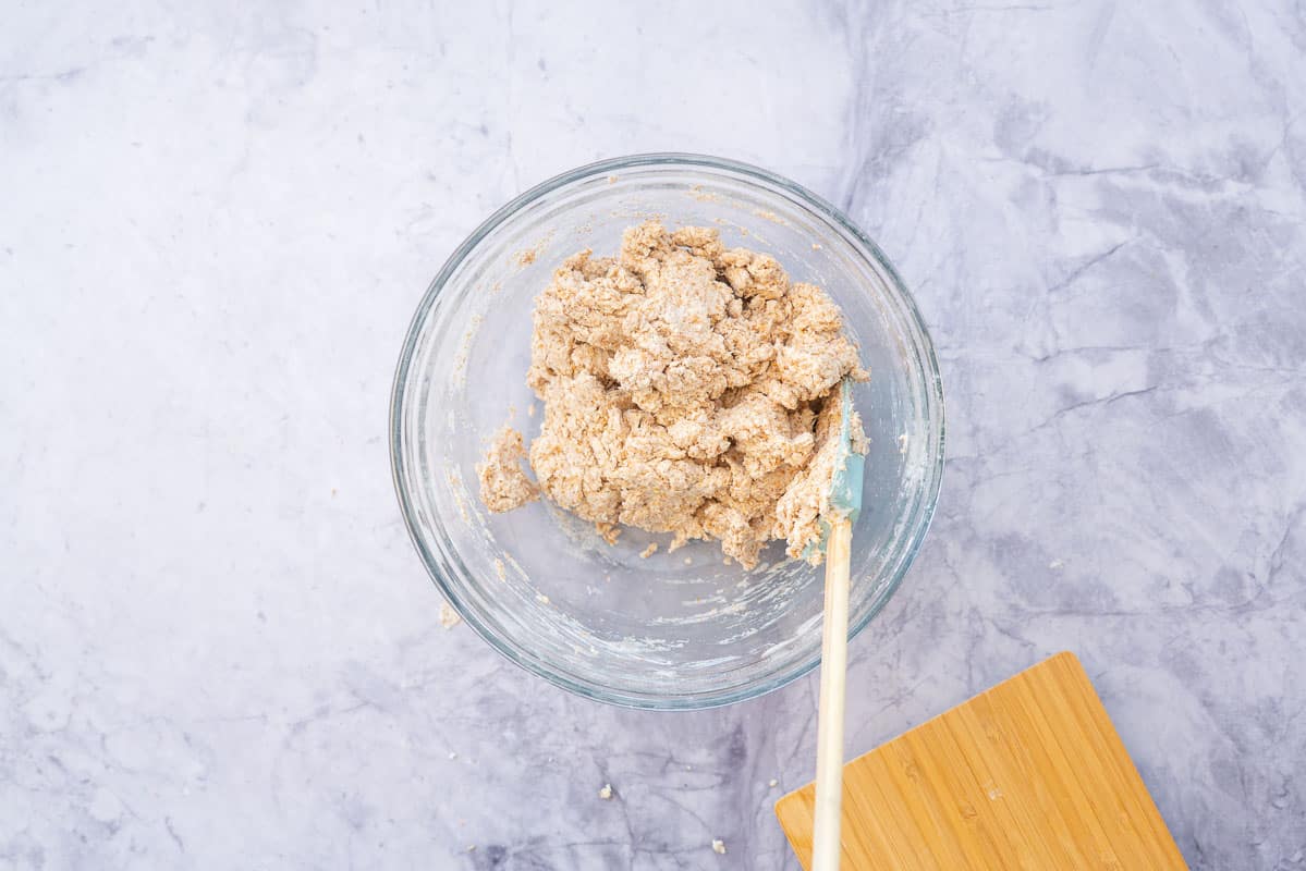 Wholemeal pizza dough in a glass mixing bowl.