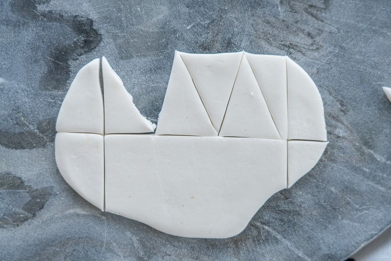 Fondant rolled flat with triangles cut out.