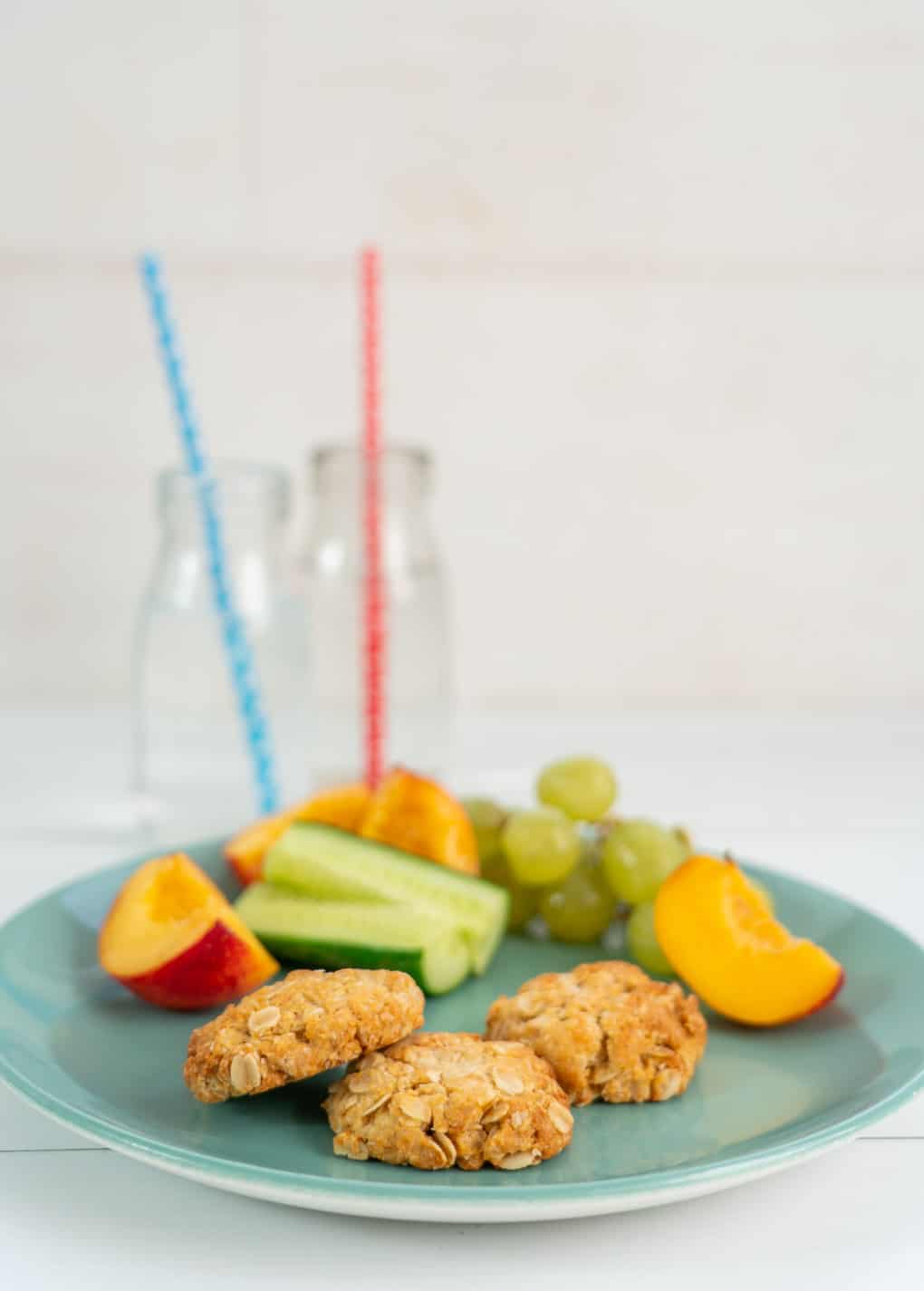 Snack plate of anzac biscuits with fruit and vegetables