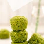 green spinach muffins stacked in a tower, a fourth muffin sits on the right of the tower