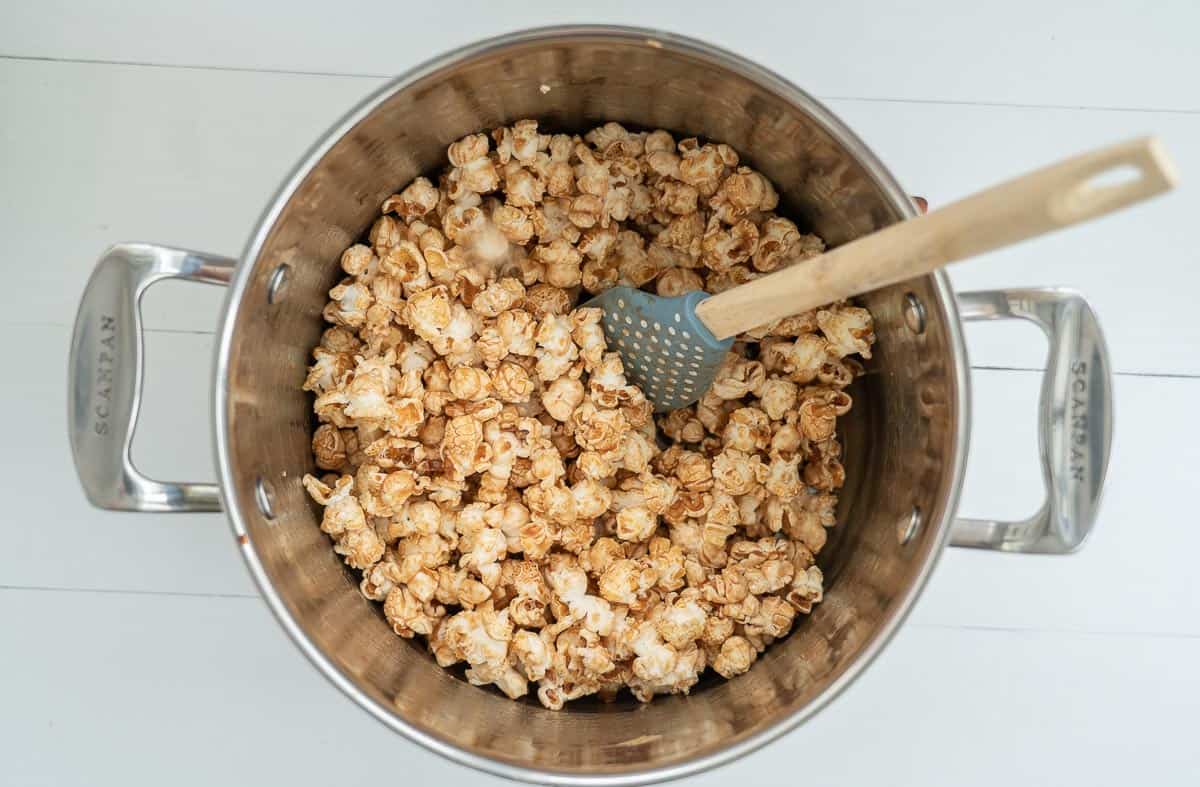 Popcorn with caramel sauce mixed through in a large saucepan