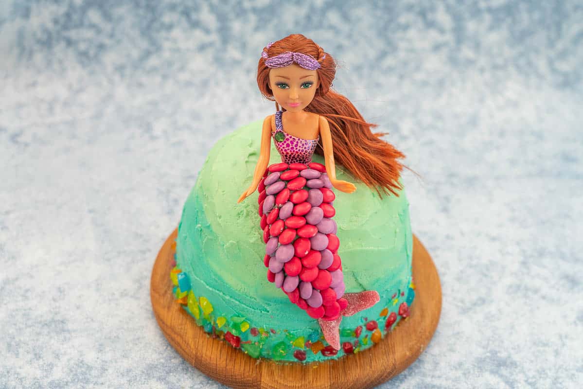 Ombre ocean coloured cake with a mermaid cake topper decorated with colourful sweets