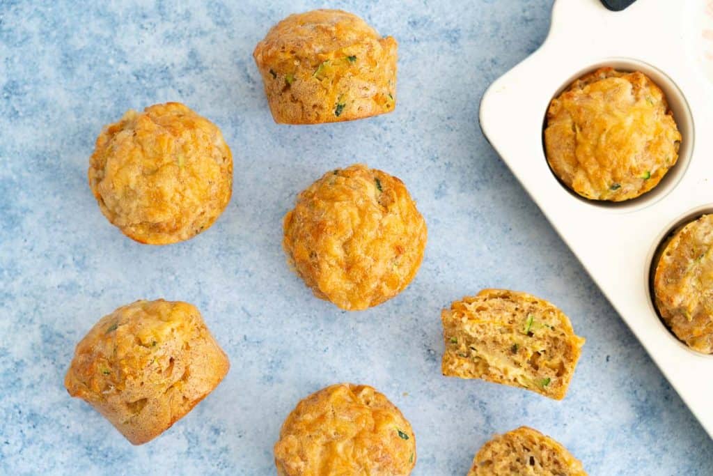 Baked muffins sitting on a blue bench top.