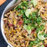 Big dish with pasta inside, topped with taco like ingredients.