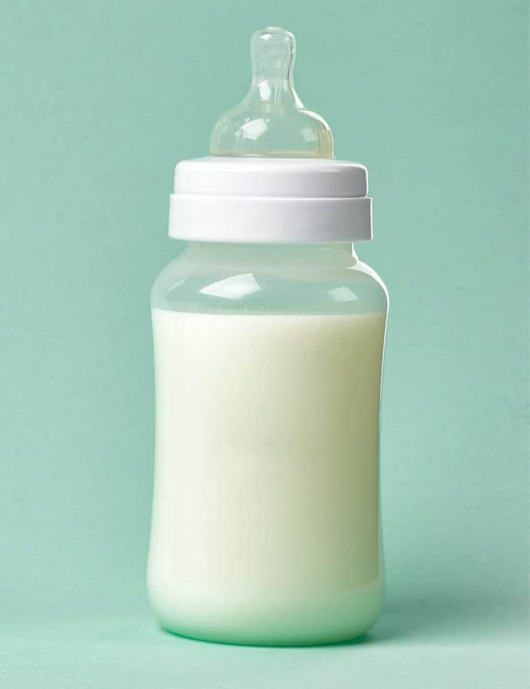 A bottle of baby formula on a green background