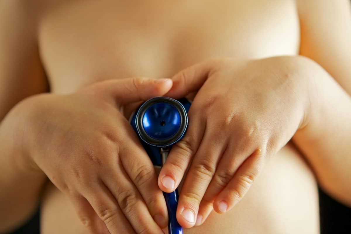 a child holding a stethoscope to their stomach.