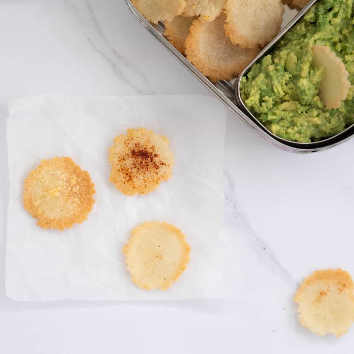 3 rice crackers on a bench top, plain, parmesan and paprika