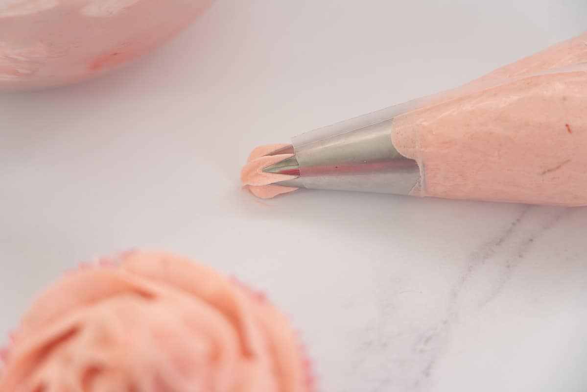 Piping bag with star tip, loaded with strawberry buttercream