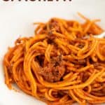 spaghetti bolognese in a white bowl with fork with text overlay
