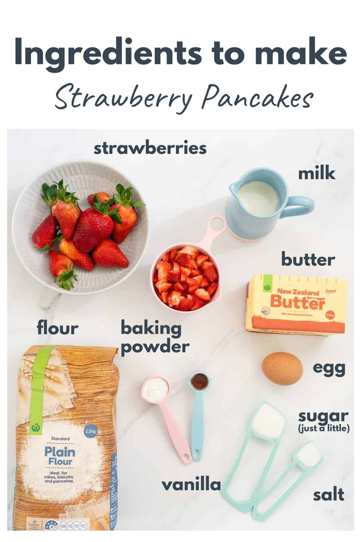 Ingredients for Strawberry pancakes laid out on bench top with text overlay.
