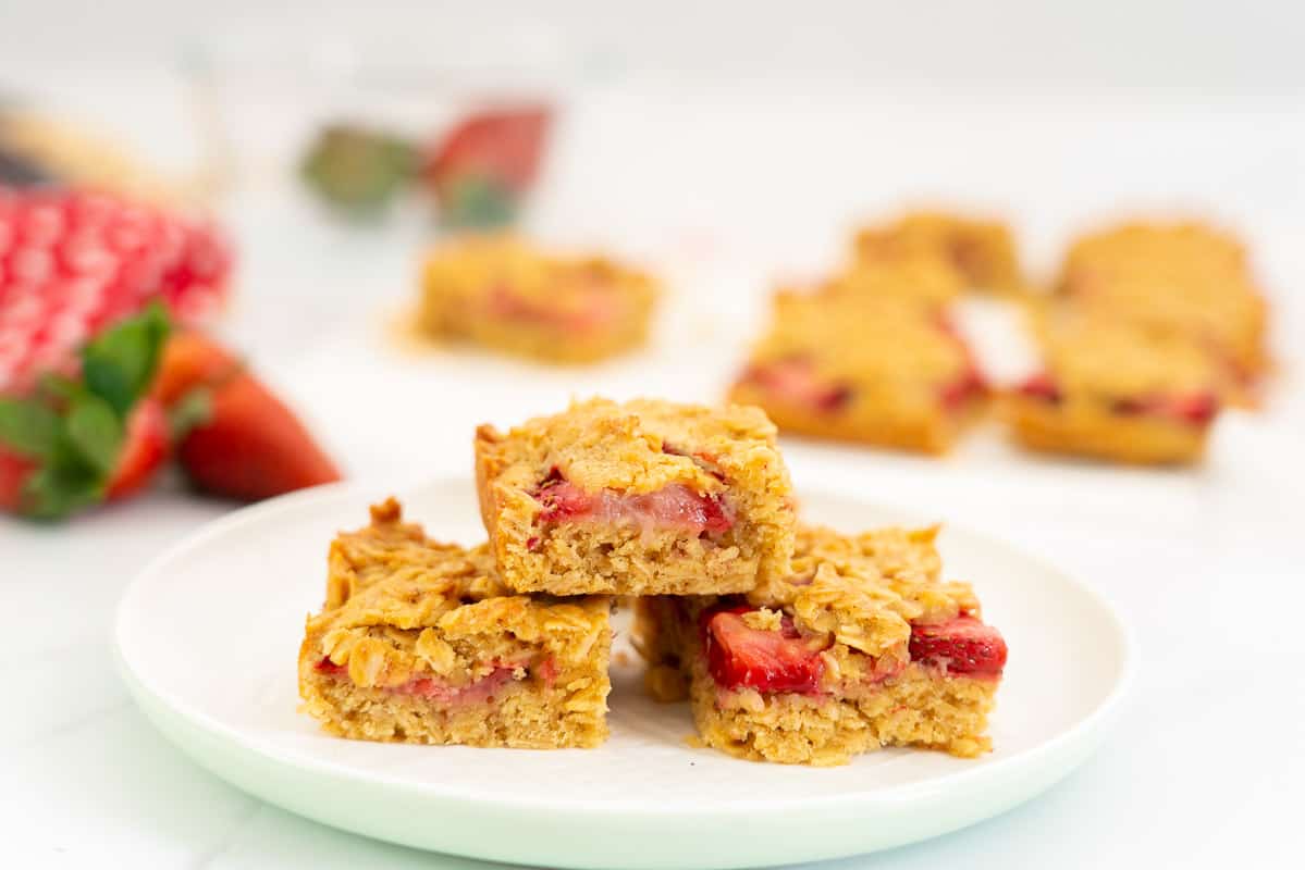 3 pieces of strawberry crumble bar stacked on a white plate