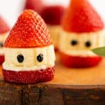 trawberry Santas sitting on a wooden board.