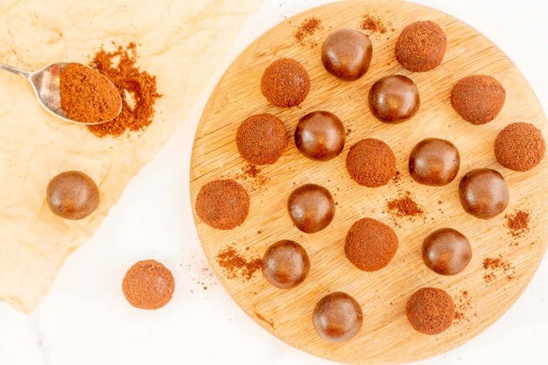 milo balls and chocolate balls on a wooden serving platter.