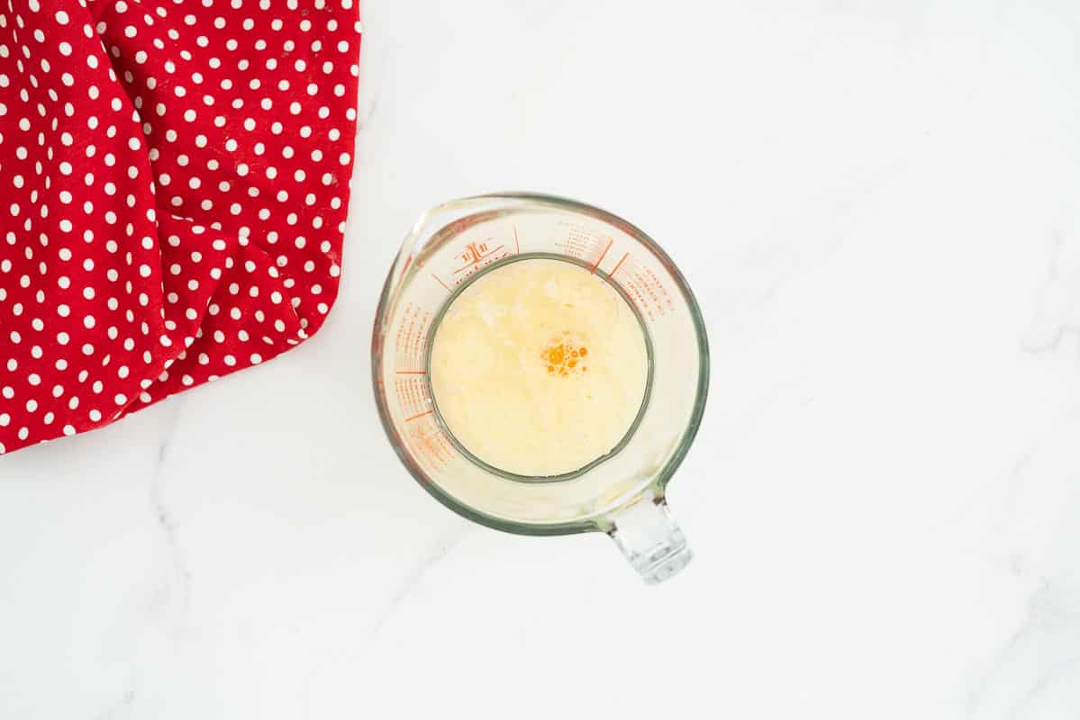 Egg, milk and vanilla in a glass jug.