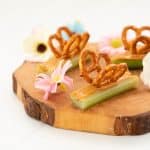 Celery sticks filled with peanut butter decorated with pretzels to form wings, making a butterfly snack.