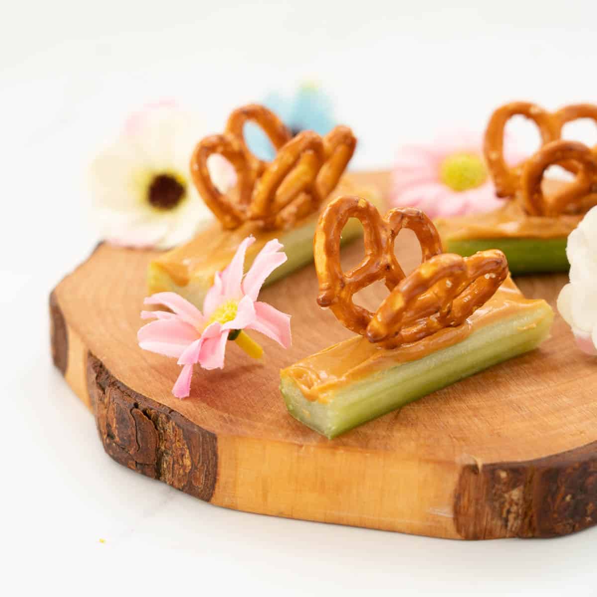 Celery sticks filled with peanut butter decorated with pretzels to form wings, making a butterfly snack.