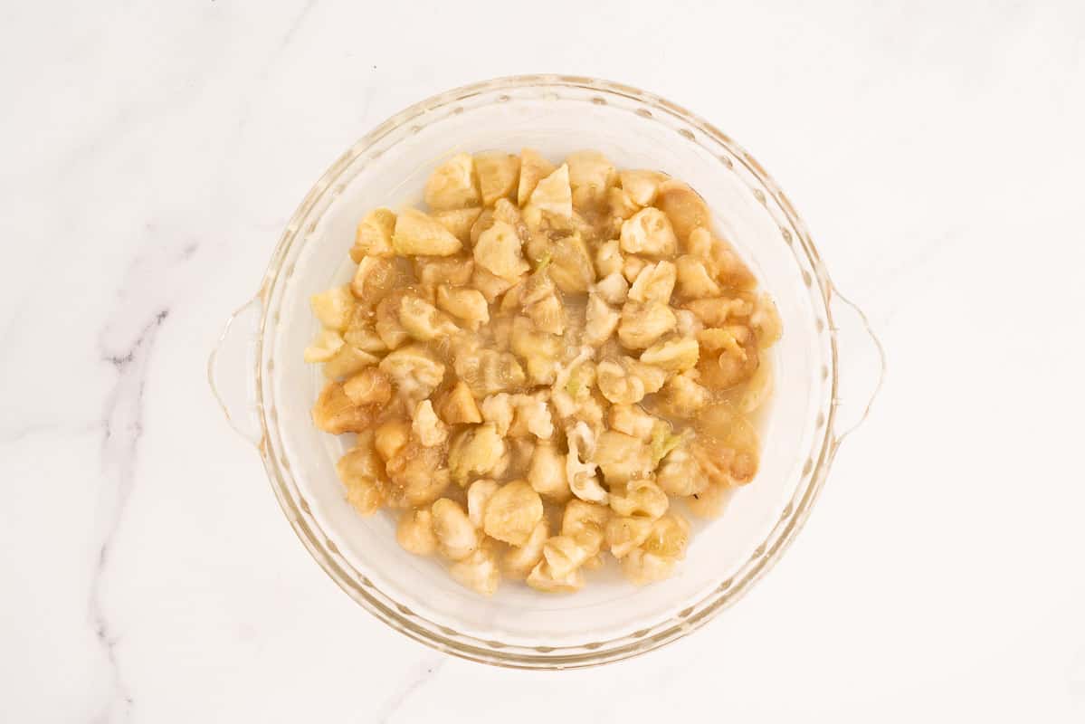 Glass pie dish filled with chopped feijoa flesh.