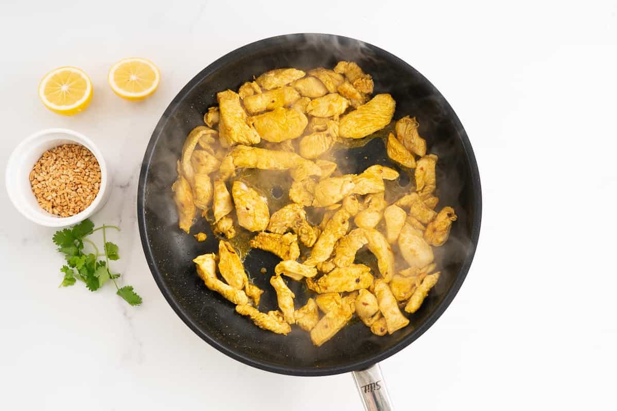 Selaed pieces of chicken breast in a large fry pan.