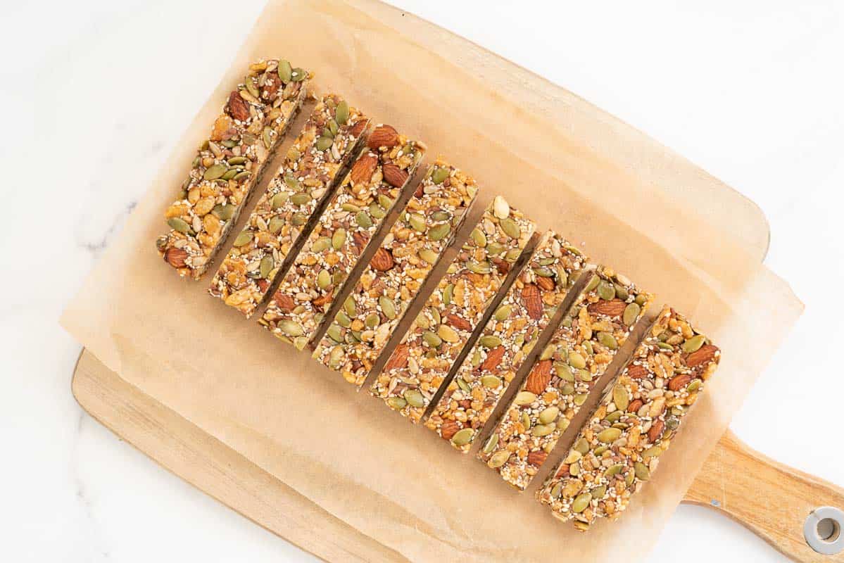 Eight energy bars sitting on a piece of baking paper.
