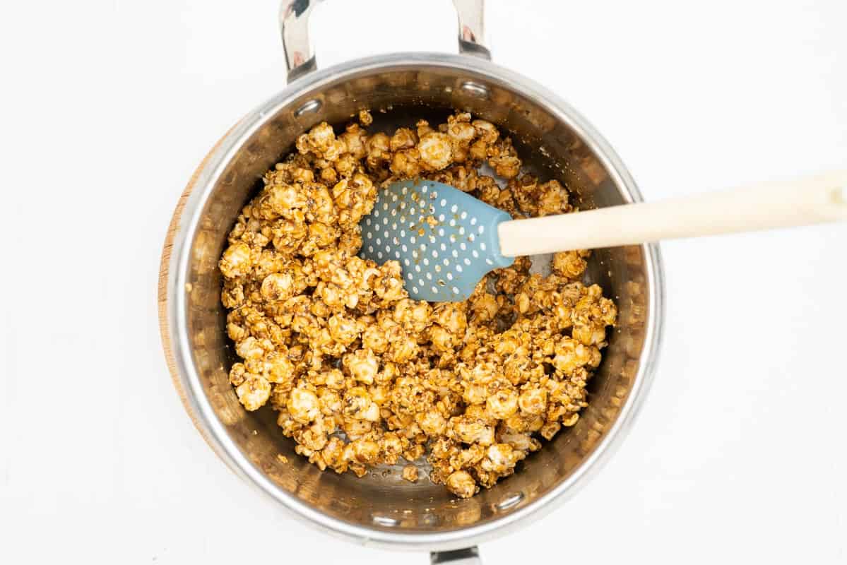 Popcorn and seeds stirred through caramel in a large saucepan.