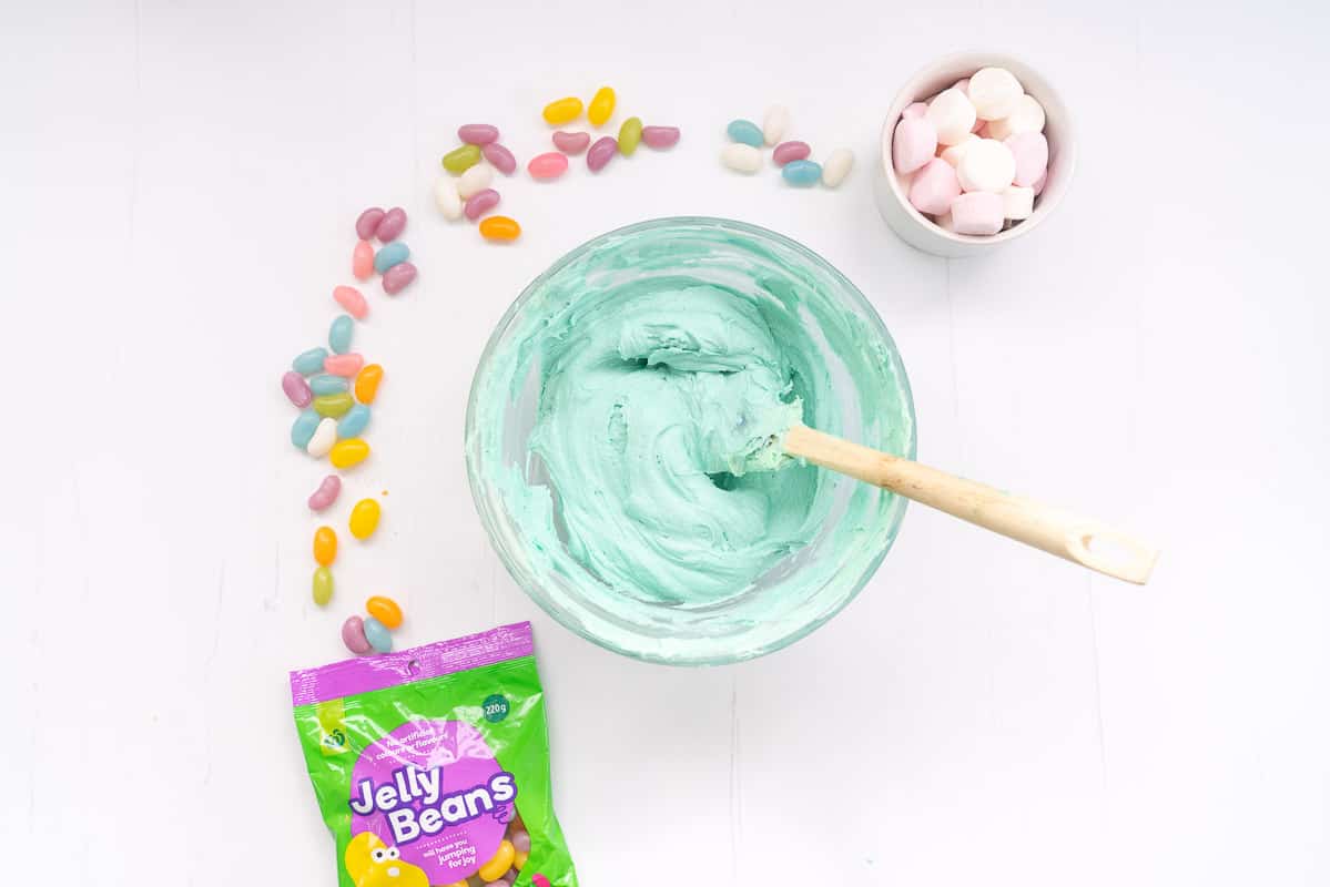 A glass bowl of light blue coloured buttercream.