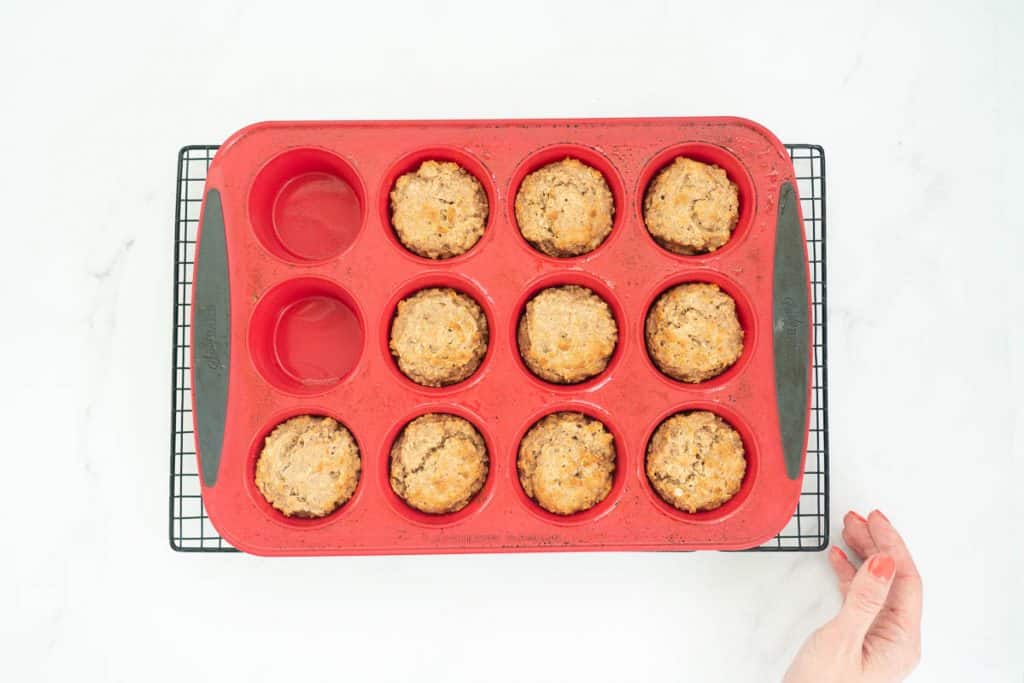 Apple toddler muffins baked to a golden colour in a red silicone muffin tray.