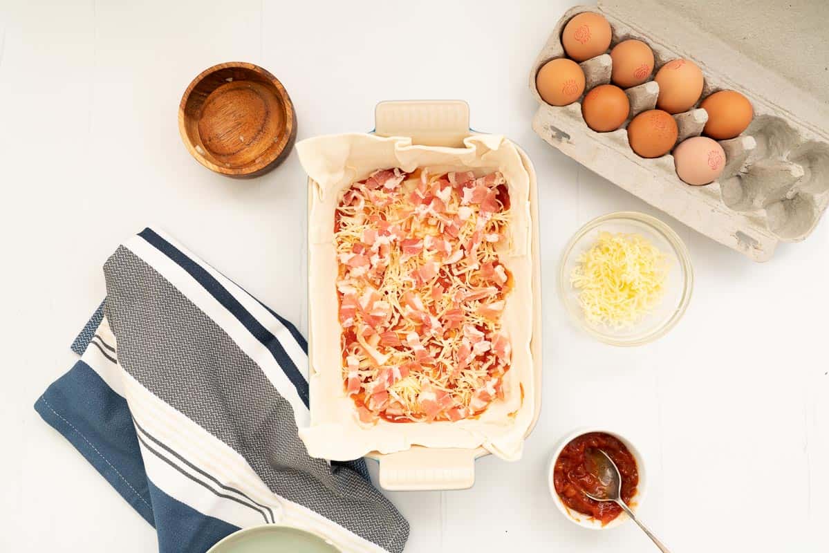 Small pieces of bacon sprinkled on the base of a pie crust.