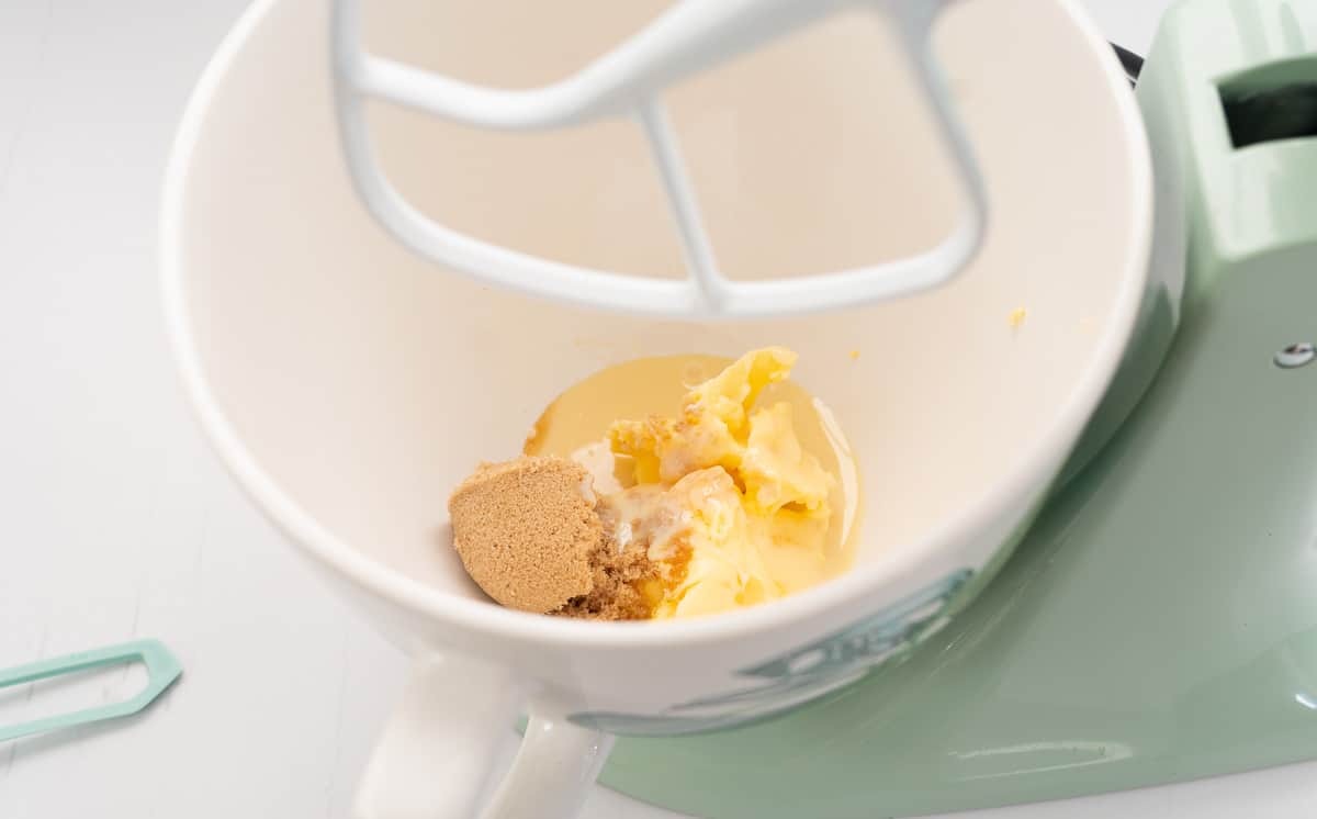 Condensed milk, brown sugar and butter in a the mixing bowl of a stand cake mixer.