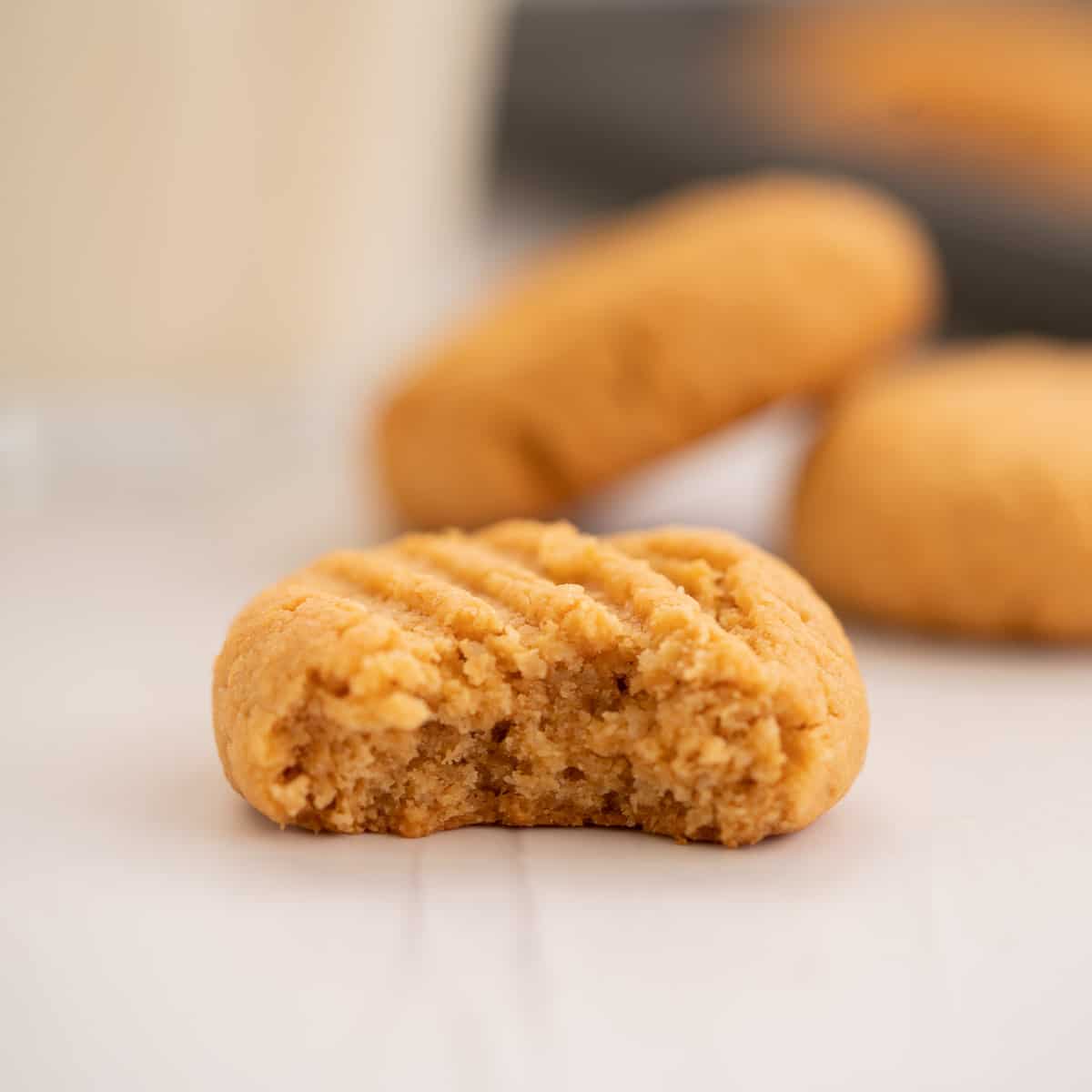 A peanut butter cookie that has been bitten in half revealing the soft cookie centre.