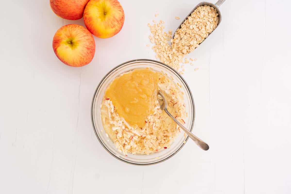 Wet ingredients in glass bowl, apple sauce visible and yet to be stirred through.
