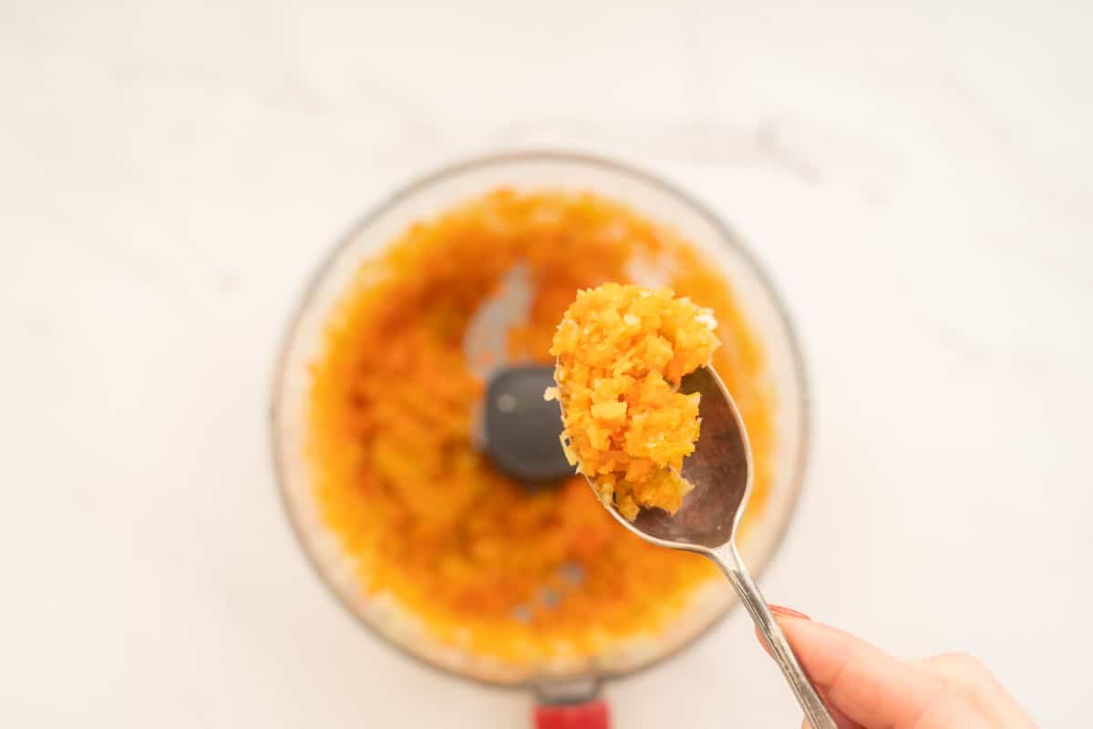 A spoonful of finely processed onion, garlic, carrot, and celery.