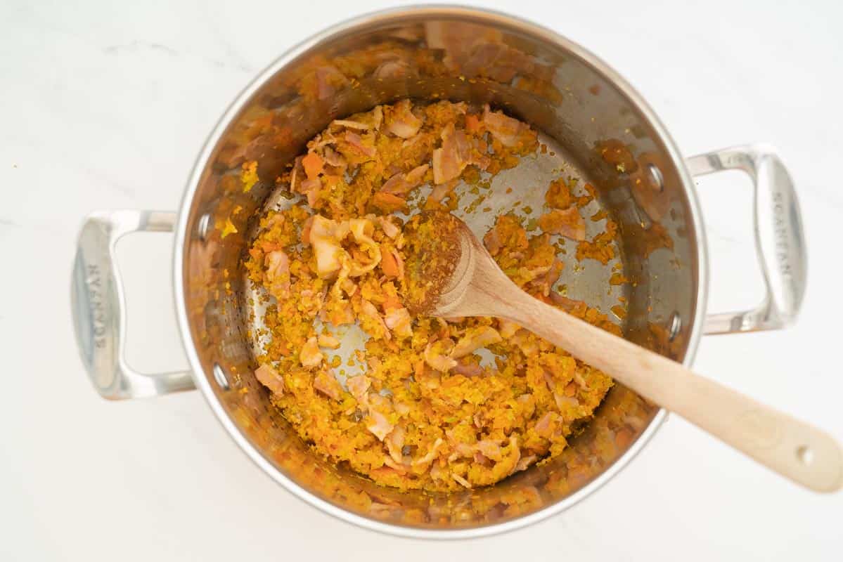 Sautéed onion, garlic, celery, carrot and bacon in the bottom of a large saucepan.