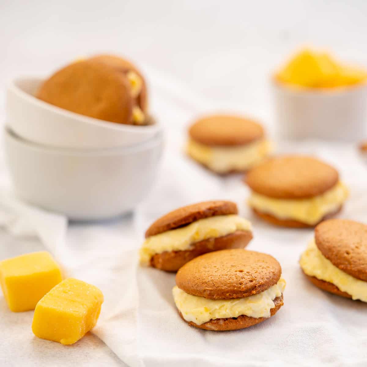 Ginger biscuits sandwiched together with mango ice cream, sittin on a crinkled white linen napkin.