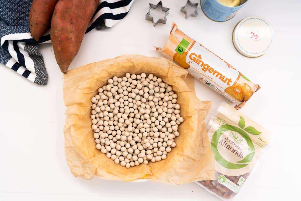 Pie crust with pastry weights ready to go into the oven to be blind baked.