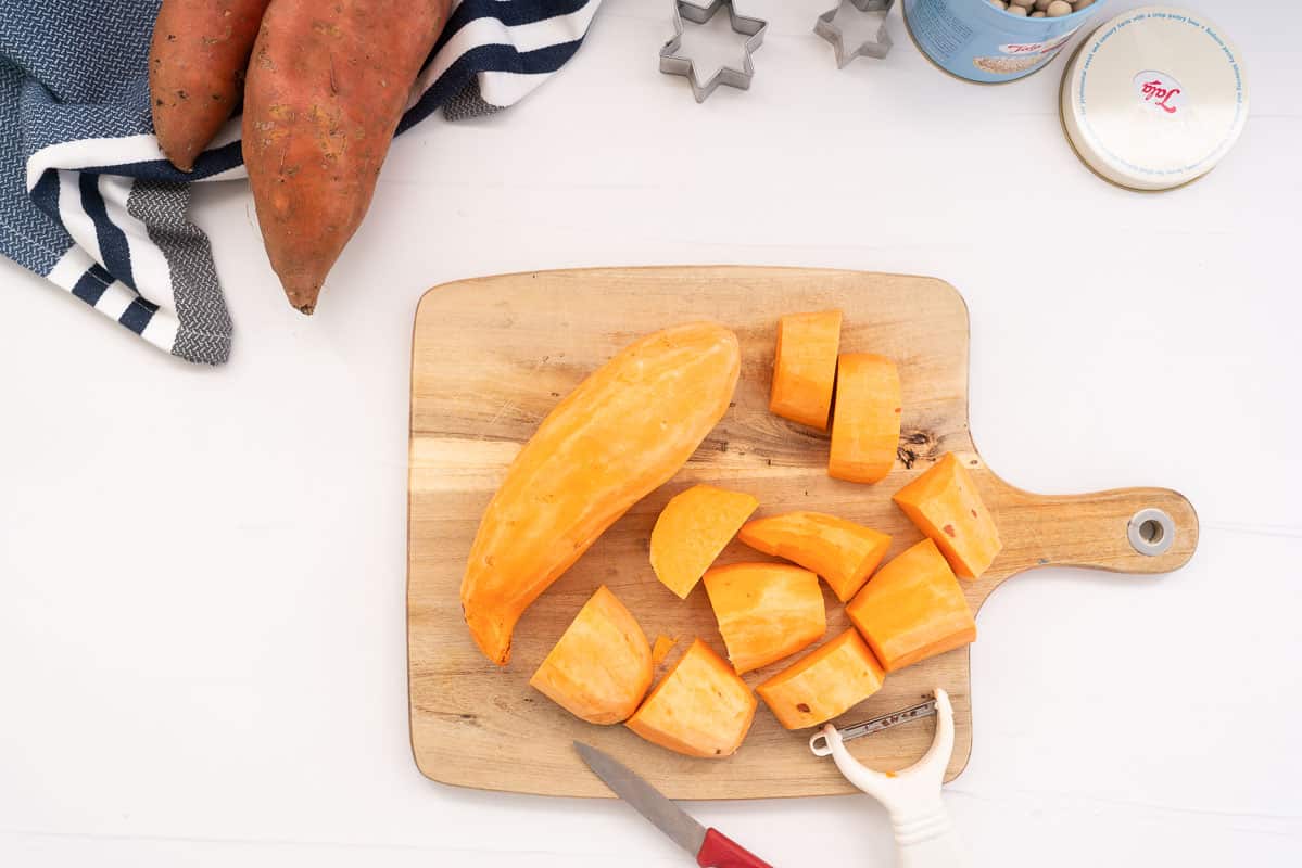 Peeled sweet potato on a wooden chopping board.