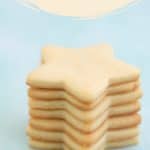 Seven star shaped sugar cookies stacked in a tower on a mint green background with text overlay.