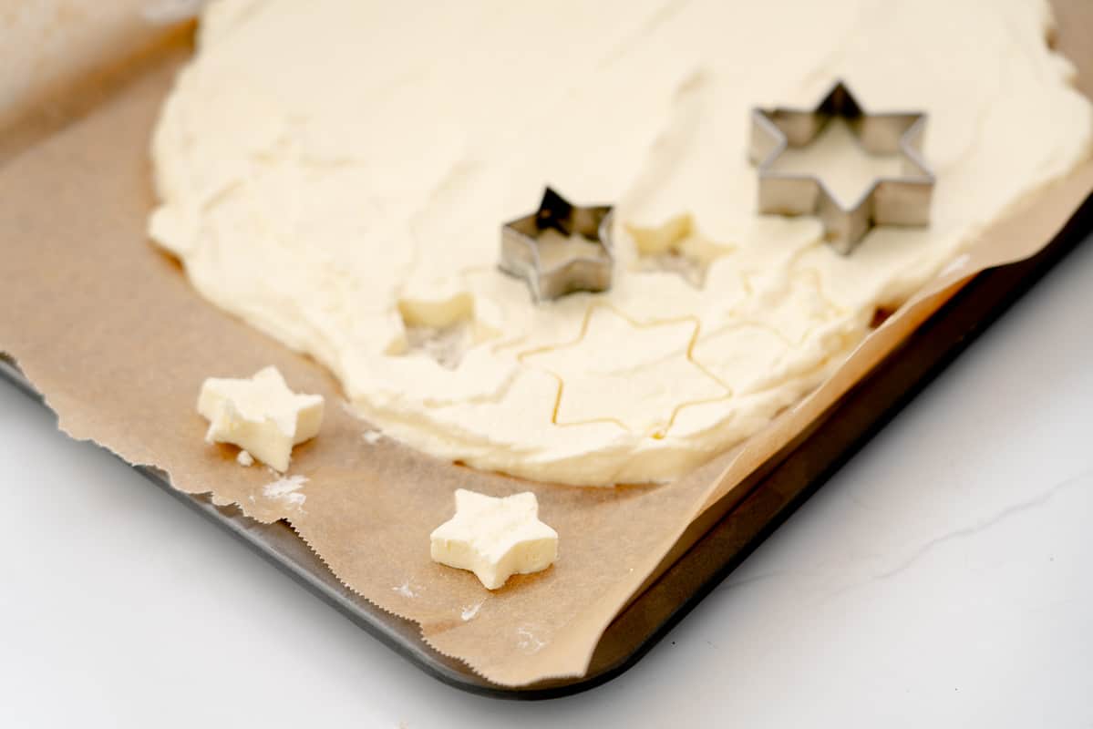 Frozen whipped cream on a tray, with star shaped cutters.