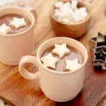 Two mugs of hot chocolate with floating star-shaped hot chocolate toppers