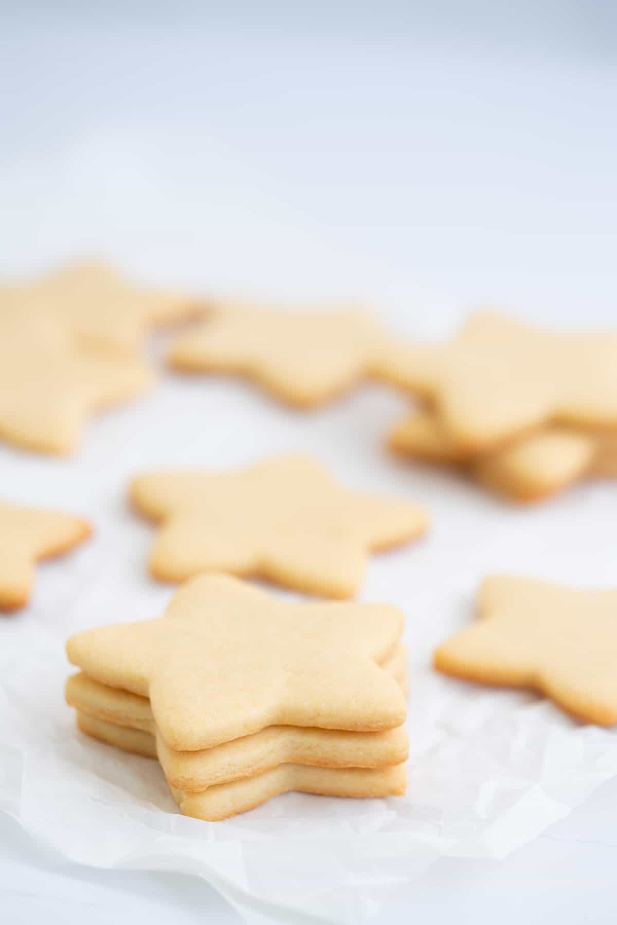 A stack of three star shaped sugar cookies on a piece of crumpled baking powder.