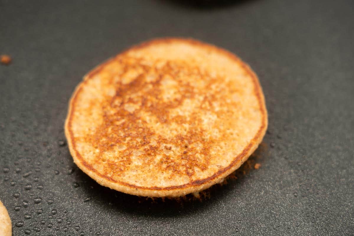 A golden brown pancake sitting on a hot plate.