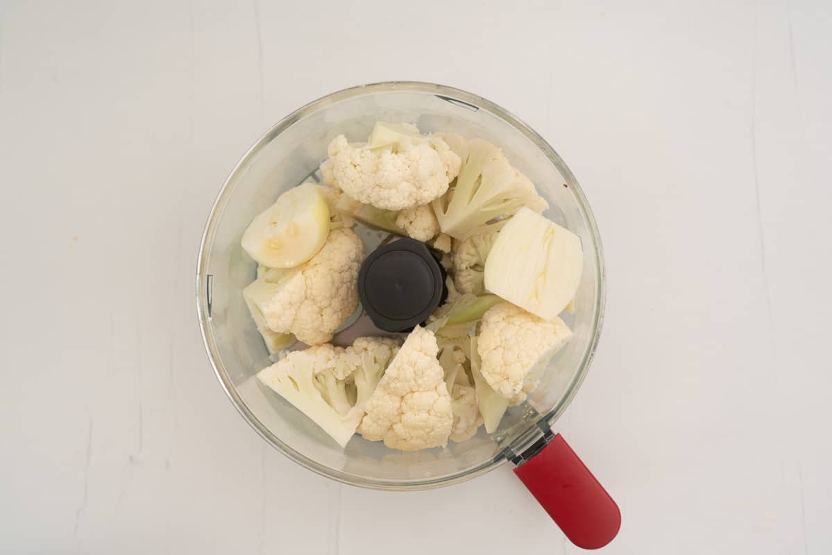 Cauliflower florets and onion in a food processor.