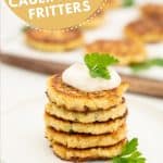A stack of 5 cauliflower fritters topped with aioli and parsley.