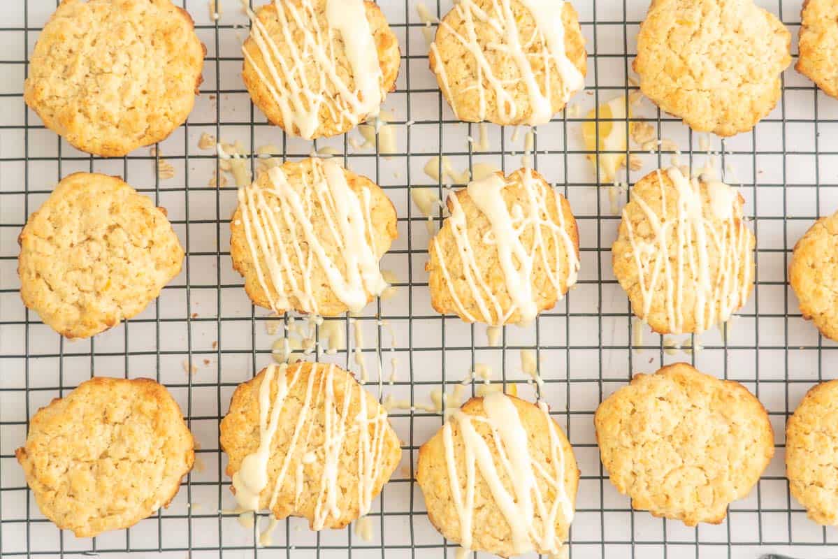 Lemon cookies on a wire cooling wrack, half drizzled with white chocolate.