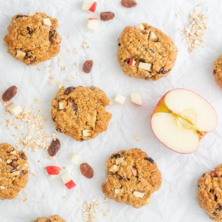 Apple cookies on bench top with a halved apple.