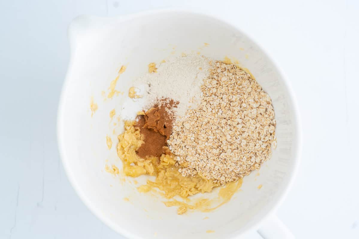 Oats, flour and cinnamon in a mixing bowl ready to be mixed into cookie dough.