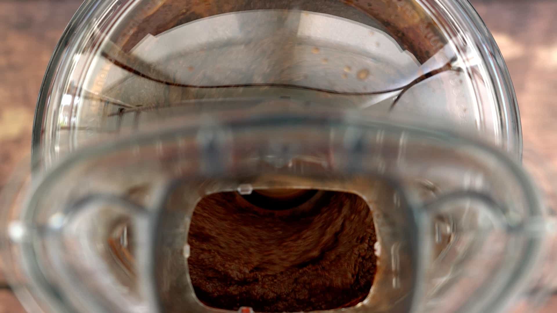 A food processor blending a smooth chocolate dip.