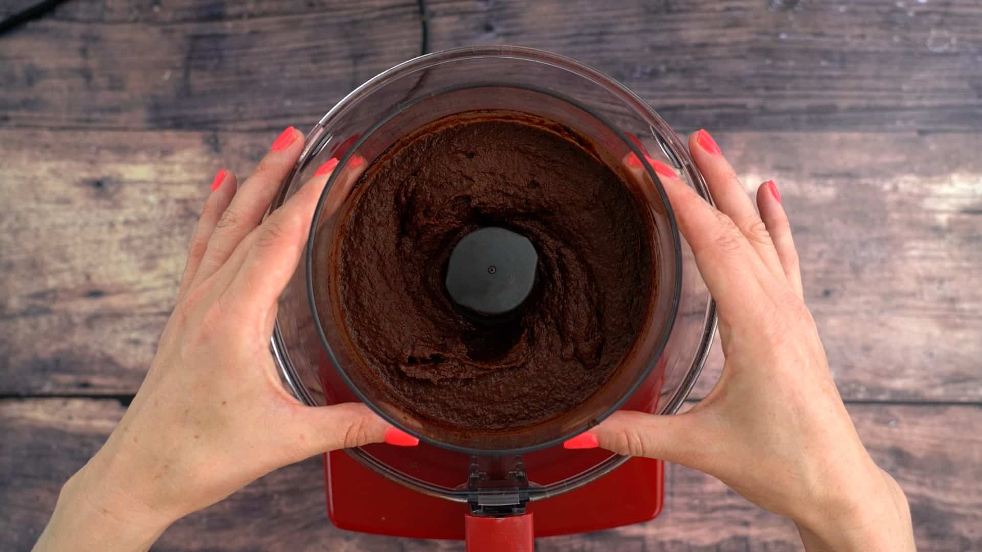 Smooth chocolate chickpea dip in the small bowl of a food processor.